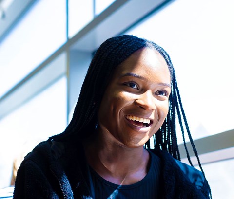 Student sitting in the library cafe with a friend and smiling