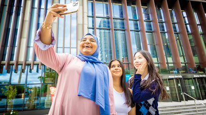 Three students taking a selfie on University of Leicester campus.