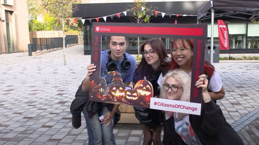 4 students holding a banner and taking a picture