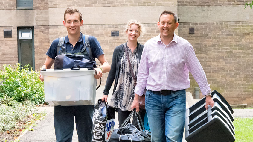 A mum and a dad moving their son into student accommodation.