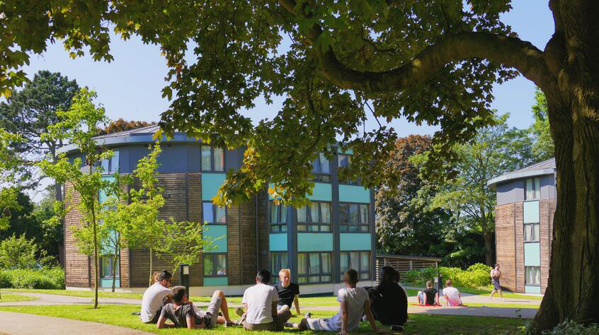 Students sitting on the grass outside the student halls in the Oadby campus of the University.
