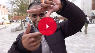 Student in Centenary Square on Leicester campus, posing for the camera.