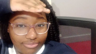 Student looking into the camera and shielding their eyes