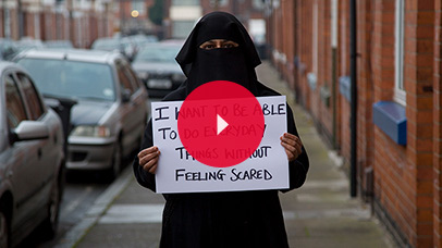 Woman in a niqab holding up a sign