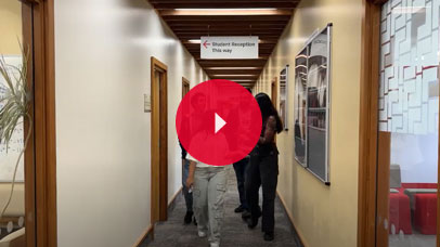Four students walking in a corridor in the Geography building.