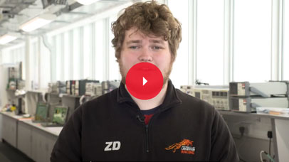 Student standing in an Engineering lab and speaking to camera.