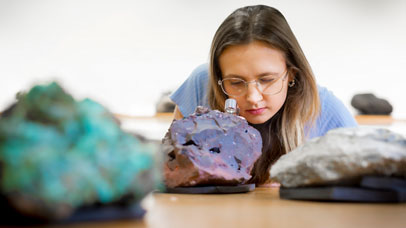 Student examining a rock