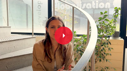 Student sitting in a stairwell and looking at the camera