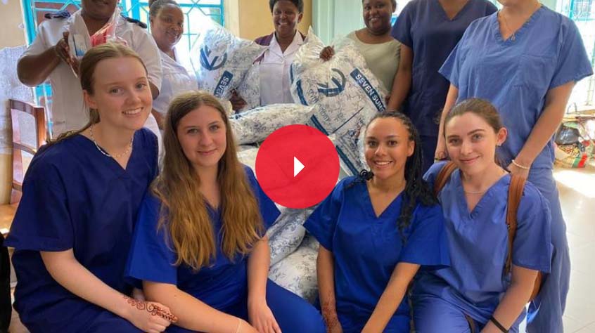 Group of midwifery students in a hospital setting looking at the camera