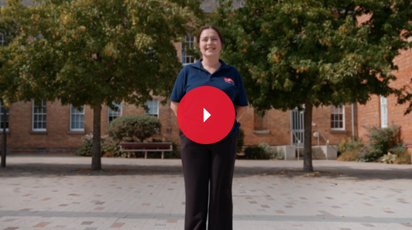 A students stands outdoors, looking at the camera.