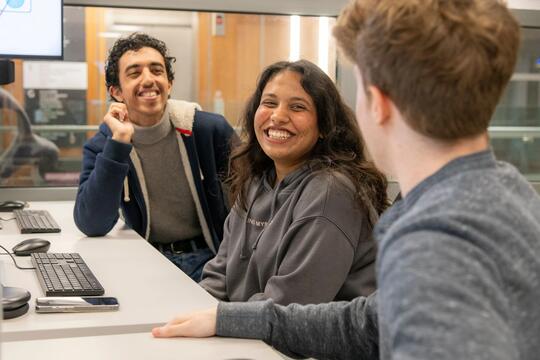 Smiling students working in a communal study area