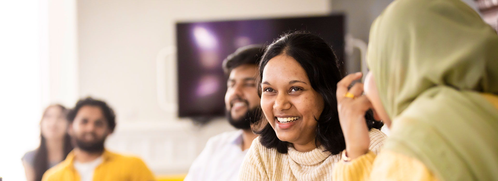 Students in a classroom, laughing and smiling.