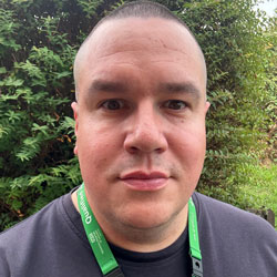 Man wearing a lanyard looking into the camera