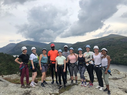 A group of WTDTP students wearing safety helmets standing on a rock on a cohort building residential