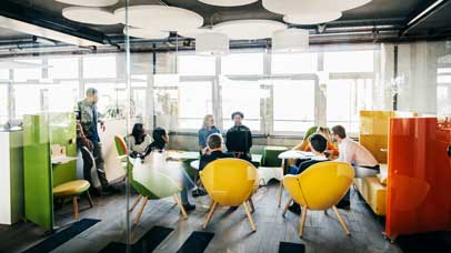 People sat in a circle in colourful chairs in an office space