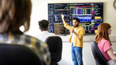 Student presenting on a large screen at the front of a class.