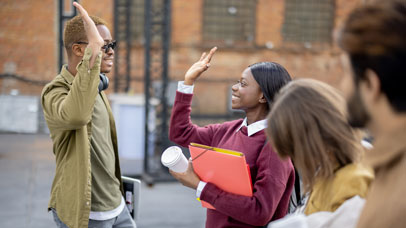 School students in a playground, high-fiving each other.