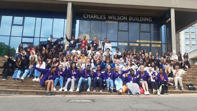 Participants of a University of Leicester Summer School, posing for a photo on the steps on the Charles Wilson building on Leicester campus