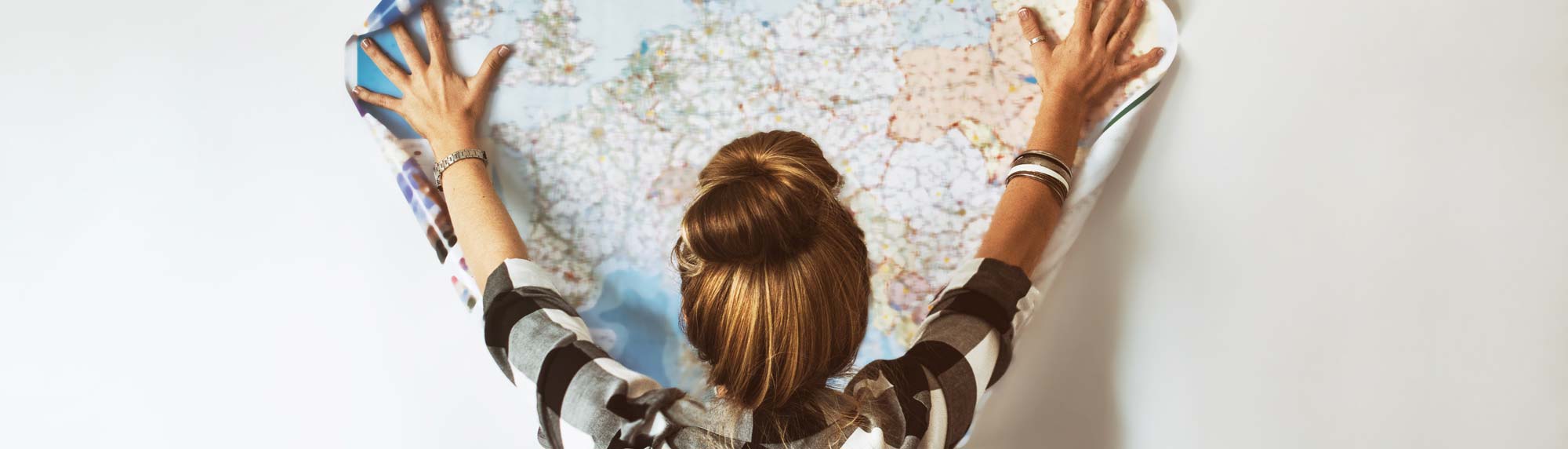 Woman holding up a large map on the wall