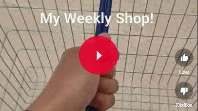 A person's hand holding a shopping basket.