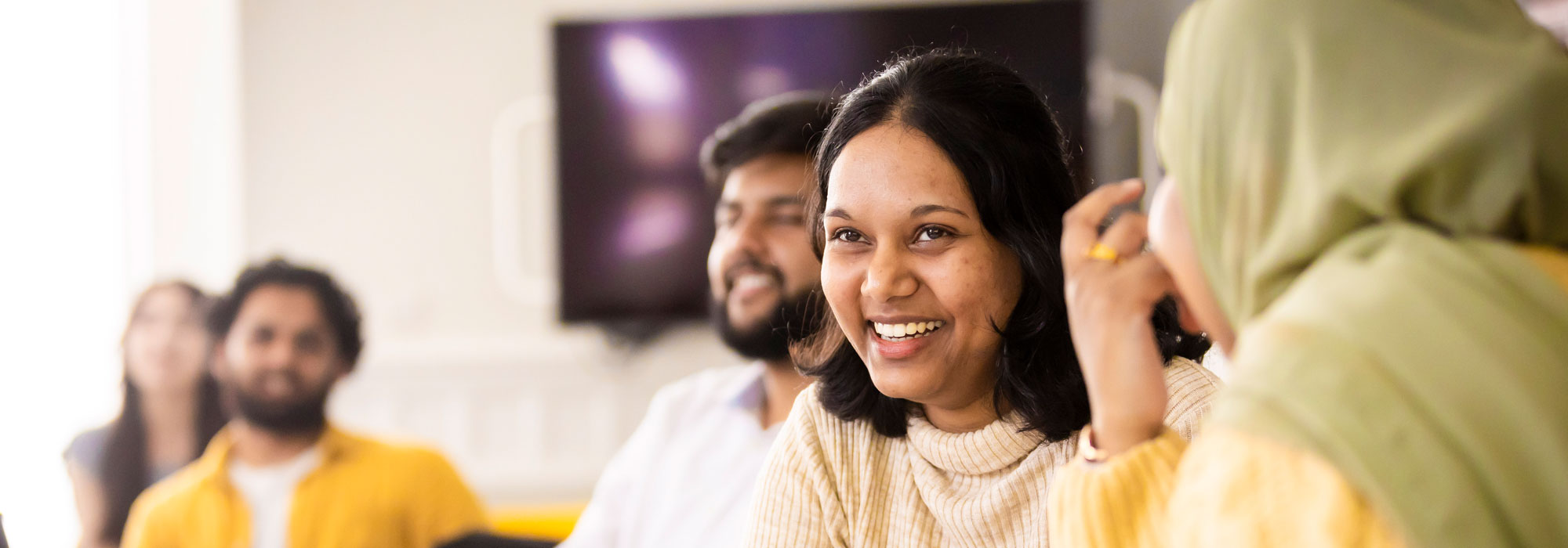 Five students listening to someone talk