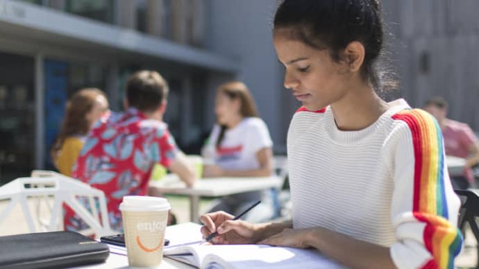 A female student studying at an outside table