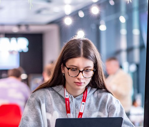 Student sitting in a busy cafe and working on a laptop