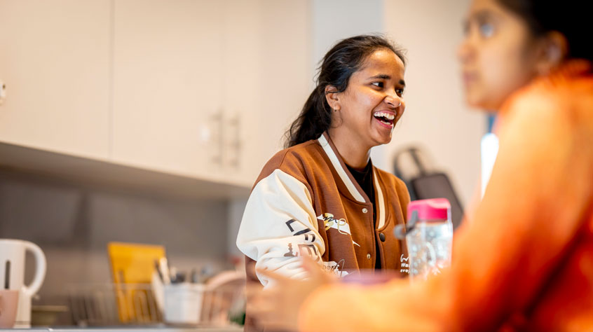 Woman in kitchen who is laughing