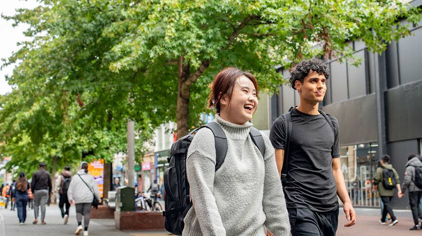 Two students walking through the University of Leicester campus