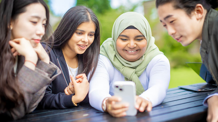 Four students taking a selfie with a mobile phone