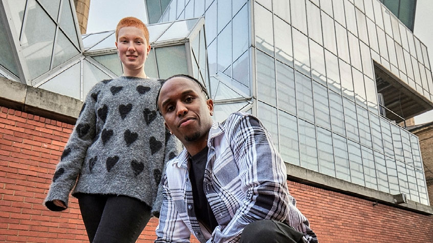 Two students standing outside the Engineering building on Leicester campus.
