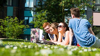 students sitting together outside accommodation buildings