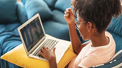 student using laptop on sofa