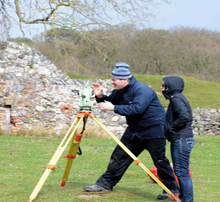 Two people surveying some land