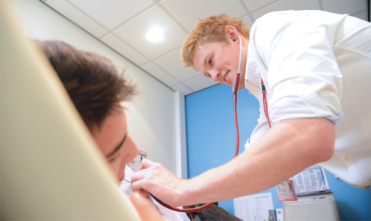 Student practising examing a patient using a stethoscope